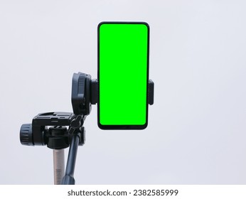 smartphone with green screen on tripod holder. smartphone mock up with chroma key - Powered by Shutterstock