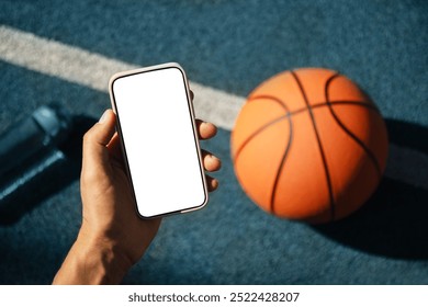 Smartphone in hands basketball player during game interval. Blank screen. Sports mock up. View from above. Close up. - Powered by Shutterstock