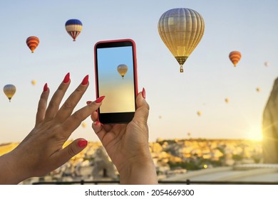 Smartphone In The Hands Of A Woman  Taking Pictures Of A Beautiful Landscape And Balloons In Cappadocia. Sunrise Time, Dreamy Travel Concept