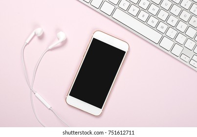 Smartphone, Headphones And Computer Keyboard On Pink And Blue Background. Technology