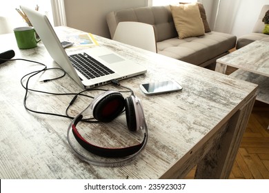 Smartphone, Headphones and Laptop on a wooden Desktop.  - Powered by Shutterstock