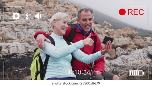 Smartphone image interface screen over happy caucasian senior couple by the sea filming selfie. active retirement, communication and social media concept, digitally generated image. - Powered by Shutterstock