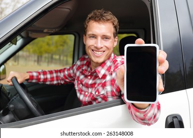 Smartphone man driving car showing app on screen display smiling happy. Male taxi driver using 4g apps showing blank empty touchscreen for gps location. Focus on model and on screen for copy space.