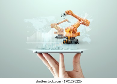 Smartphone in a man's hand and robotic arms of a modern plant. Iot technology concept, smart factory. Digital manufacturing operation. Industry 4.0. - Powered by Shutterstock - Get 15% off with code: PIKWIZARD15