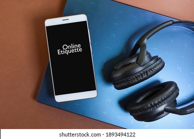 A Smartphone With Message On Online Etiquette With A Headphone On The Laptop Isolated On The Brown Background