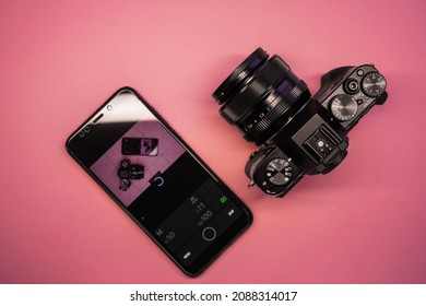 smartphone and mirrorless camera top view. phone camera control. modern photographer gadgets