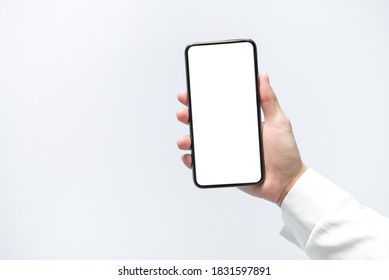 Smartphone mockup. Close up hand holding black phone white screen. Isolated on white background. Mobile phone frameless design concept.