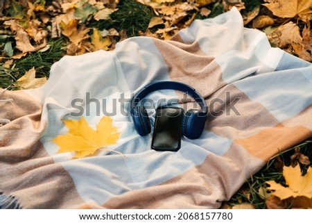 Smartphone mockup, headphones, yellow maple leaf on blanket in autumn park background. Audio technology apps, meditation application, fall mood music podcasts and books Stock photo © 