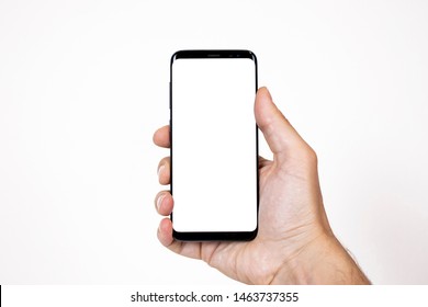 Smartphone mockup image of a man hand holding black mobile phone with blank screen on isolated background - Shutterstock ID 1463737355