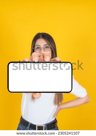 Smartphone mockup, portrait of young woman holding smartphone mockup. Caucasian girl showing  horizontal mobile phone with white blank close up empty screen. Blurred face, looking to camera. 