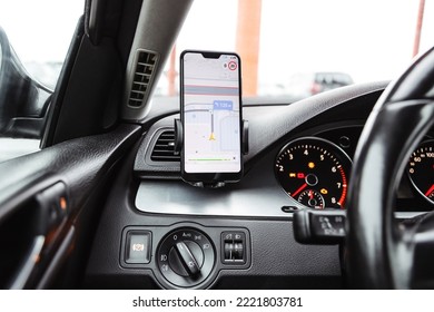 Smartphone with navigation route on screen mounted on phone holder at car dashboard