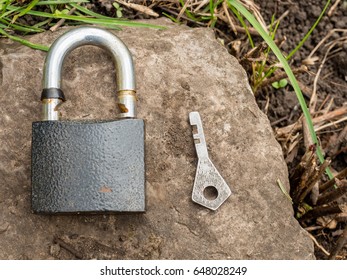 Smartphone, old key, lock - security, caution - idea, concept. Against the background of the old stone.