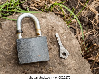 Smartphone, old key, lock - security, caution - idea, concept. Against the background of the old stone.