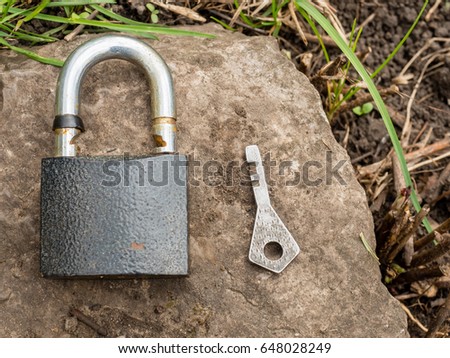Smartphone, old key, lock - security, caution - idea, concept. Against the background of the old stone.