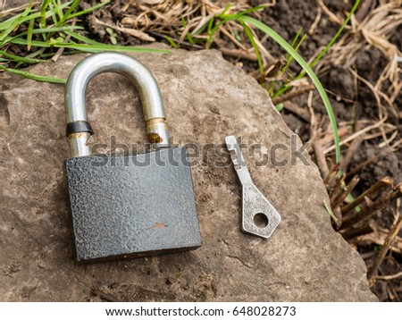 Smartphone, old key, lock - security, caution - idea, concept. Against the background of the old stone.