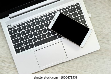 Smartphone sur l'ordinateur portable sur une table en bois 