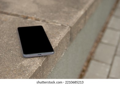 Smartphone On Street Curb Outdoors. Lost And Found