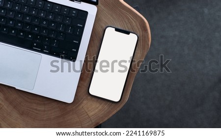 smartphone on a white background lies on a wooden table.