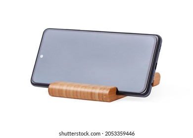 Smartphone on wooden stand isolated on white