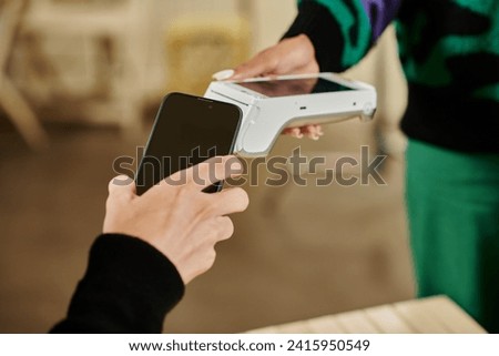 smartphone payment, cropped view of man holding his smartphone near card reader in vegan cafe