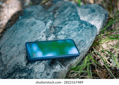 Smartphone in a Protective Case Resting on a Rock in Nature