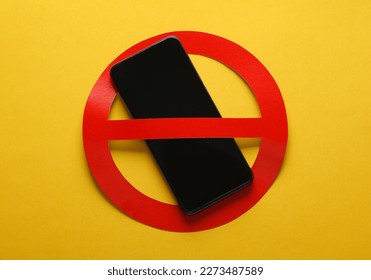 Smartphone with red prohibition sign on yellow background. Ban - Shutterstock ID 2273487589