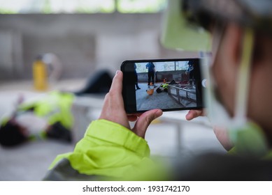 Smartphone shooting on accidents and Unconscious of worker in workplace at construction site area while having the Medical assistance first aid team with equipment.