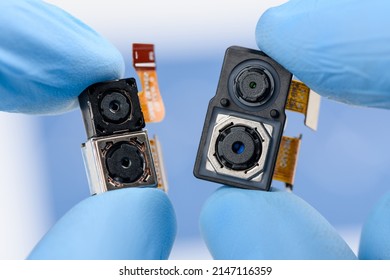 Smartphone single and dual camera modules in scientist hands. Different sensor sizes and technology used.