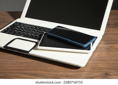 Smartphone, tablet, laptop computer on the wooden table. - Shutterstock ID 2280718733