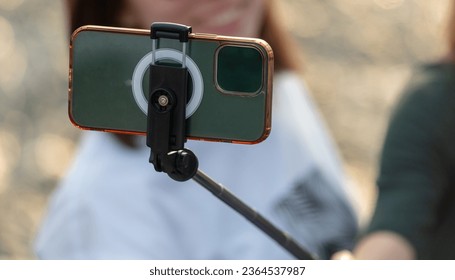 The smartphone takes photos using a selfie stick. Close-up. - Shutterstock ID 2364537987