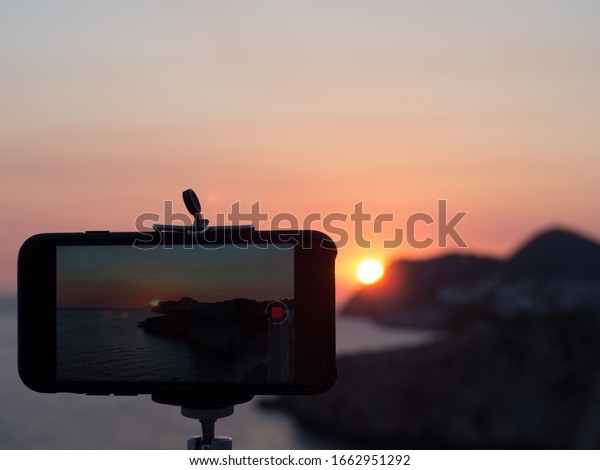 Smartphone taking a\
timelapse video of a\
sunset