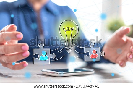 Smartphone with teamwork idea concept between hands of a woman in background