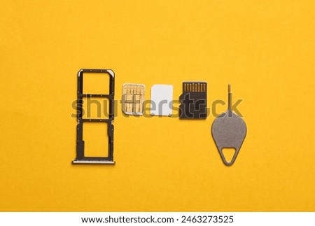 Smartphone Tray with SIM and micro SD memory cards on a yellow background. Flat lay