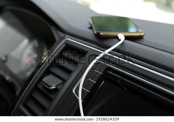 Smartphone with USB\
charging cable in modern\
car