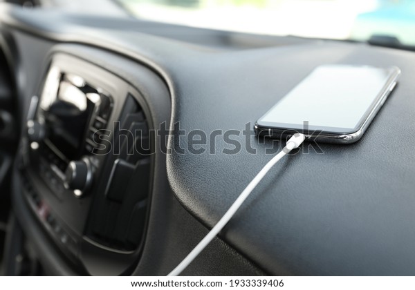 Smartphone with USB\
charging cable in modern\
car