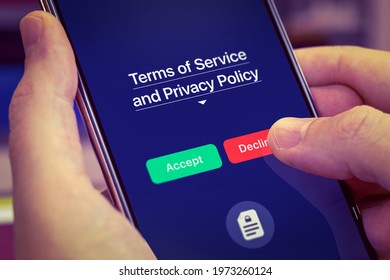 Smartphone user refuses to accept Terms of Service and Privacy Policy mobile app. Dark app interface with Accept and Decline buttons. Finger touches the Decline button