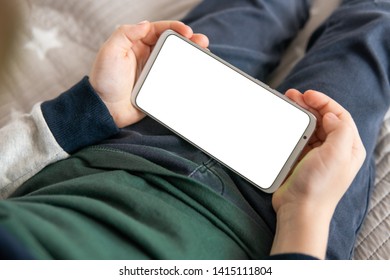 Smartphone With A White Screen In Hand Child. Phone A For Mock Up Is Holding Kid. Smartphone With A Mock Up In The Hands Of A Child. Top View Close Up