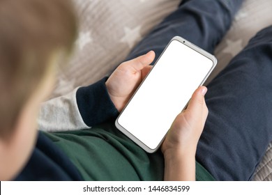 Smartphone With A White Screen In Hand Child. Phone A For Mock Up Is Holding Kid. Smartphone With A Mock Up In The Hands Of A Child. Close Up Top View