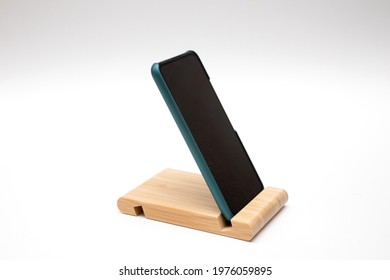 Smartphone in a wooden stand on the table.