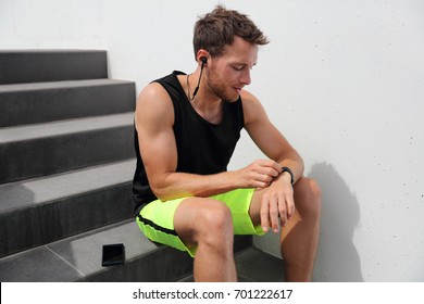 Smartwatch Runner Man Checking Progress On Smart Fitness Sport Watch During Running Break After Hiit Stairs Cardio Workout Training. Athlete Using Online App On Wearable Device. Active Lifestyl.