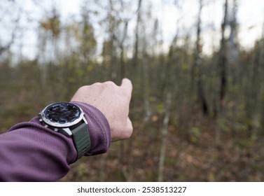 Smartwatch travel. Hiker with sports watch in Expedition. Watch for wild survival. Tactical, hiking Watch on hand. GPS track Smartwatch. Traveler with watch in adventure. Hand Pointing Direction. - Powered by Shutterstock