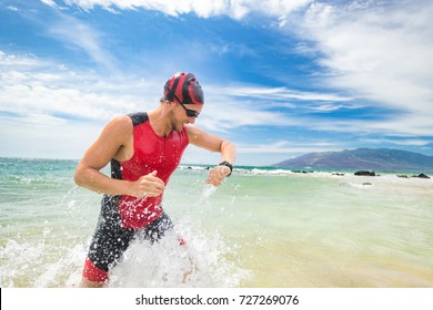 Smartwatch Triathlon Swimming Sport Man Finishing Swim Checking Heart Rate On Smart Watch. Male Triathlete Swimmer Running Out Of Ocean. Professional Athlete In Triathlon Suit Training For Ironman.