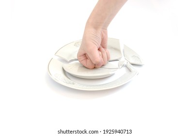 Smash The Plate With Your Fist Against The White Background. Broken Plate In The Hand Of A Child. Offended Man Beats Dishes Isolated On White. 