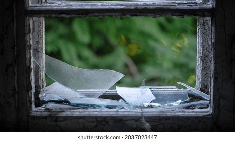 Smashed Glass Window With Old Wooden Frame. Old Window. Finely Broken Glass. Old House, Retro. Cracked Window Frame. Cracked Old Paint, Pieces Of Glass. Close-up, Space For Text. Horror, Halloween