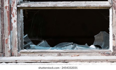 Smashed glass Window with old wooden frame. old window. finely broken glass. old house, retro. cracked window frame. cracked old paint, pieces of glass. close-up, space for text. large pieces of glass - Powered by Shutterstock