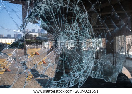 The smashed glass window of a shop window in rioting and looting July 2021