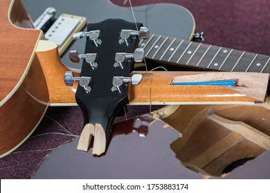 Smashed Guitars. Pile Of Broken Electric And Acoustic Guitar Bits. Close-up Of Damaged Musical Instruments Including Headstock, Neck And Body Of Various Guitars. Frustrated Guitarist.