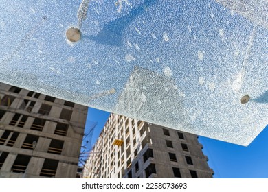 Smashed transparent awning made of tempered glass over entrance door of multi-storey residential building, broken due to construction in neighborhood - Shutterstock ID 2258073693