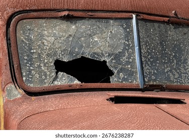 Smashed windshield on a rusted defunct antique truck