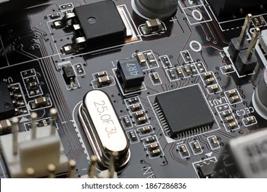 Smd chip ethernet microcontroller on brown motherboard with a lot of surface mount components resistors, capasitors, transistors, crystal oscilator, inductor and plugs.